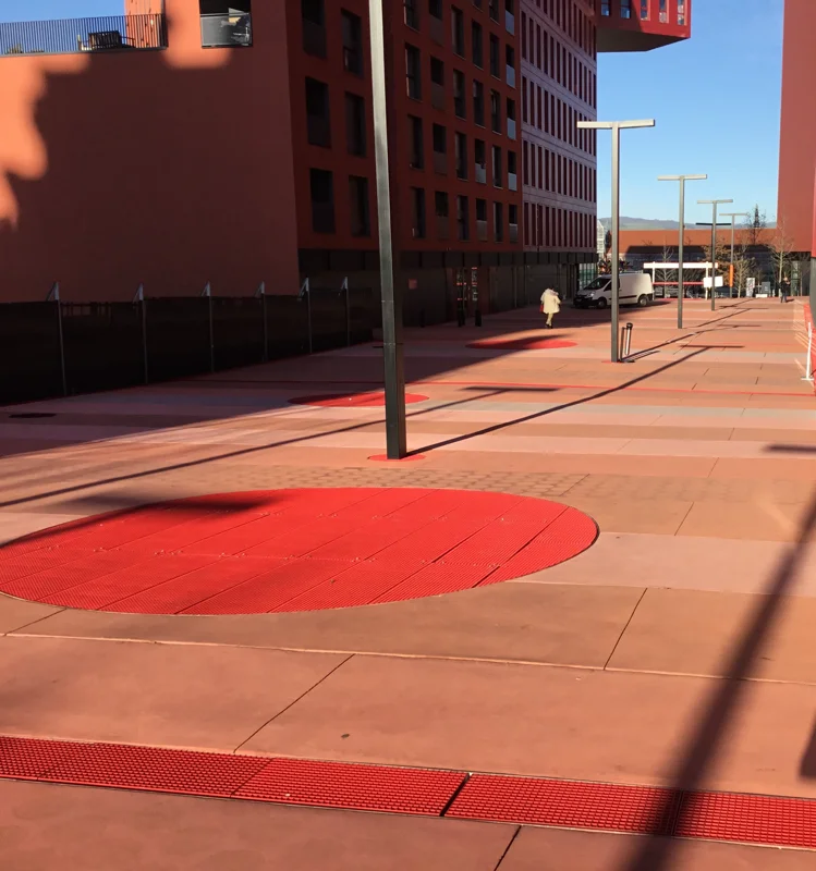 Grating with red powder coat finish on a railway station forecourt