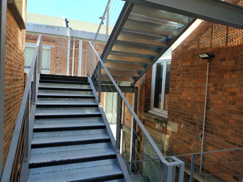 Escalier avec marches en grille PS-PMR avec nez peint et contremarche.