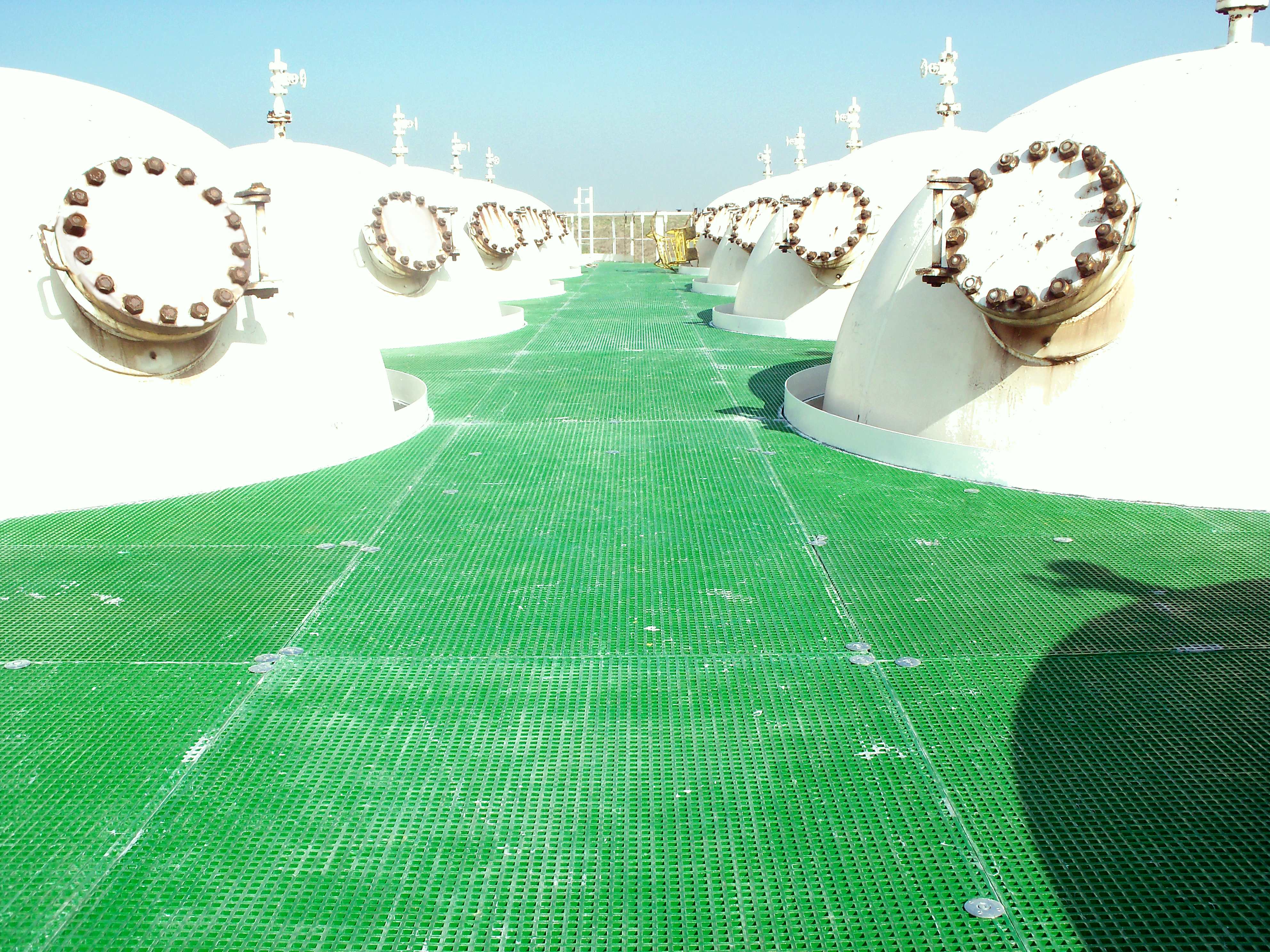 Sol en caillebotis polyester entouré de réservoirs de stockage