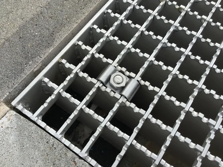 attache de fixation par cavalier sur un caillebotis galvanisé