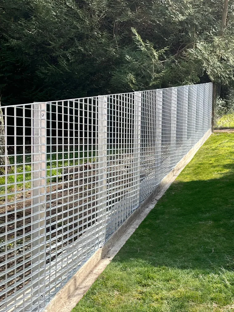 clôture en caillebotis galvanisé délimitant des espaces verts