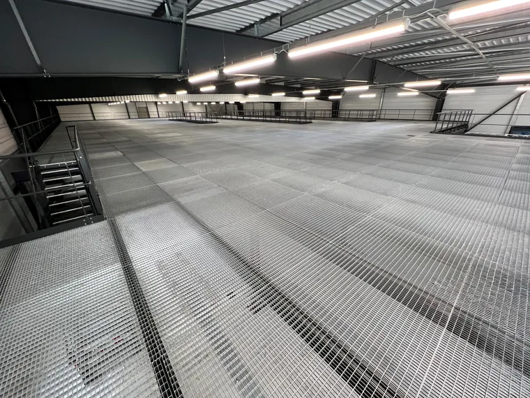 plancher de mezzanine en caillebotis acier galvanisé dans un bâtiment industriel