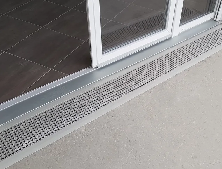 seuil de porte PMR en caillebotis polyester devant une porte-fen&ecirc;tre