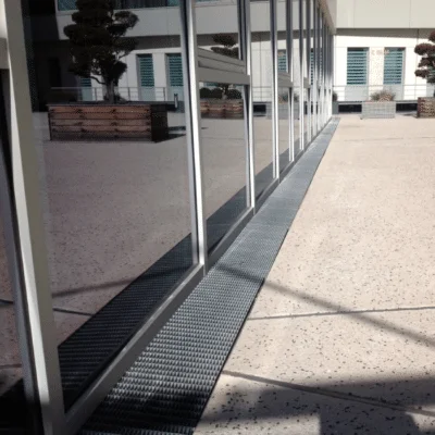 référence réalisation caille boti utilisé en grille caniveau pour collecter les eaux de pluie devant un bâtiment public