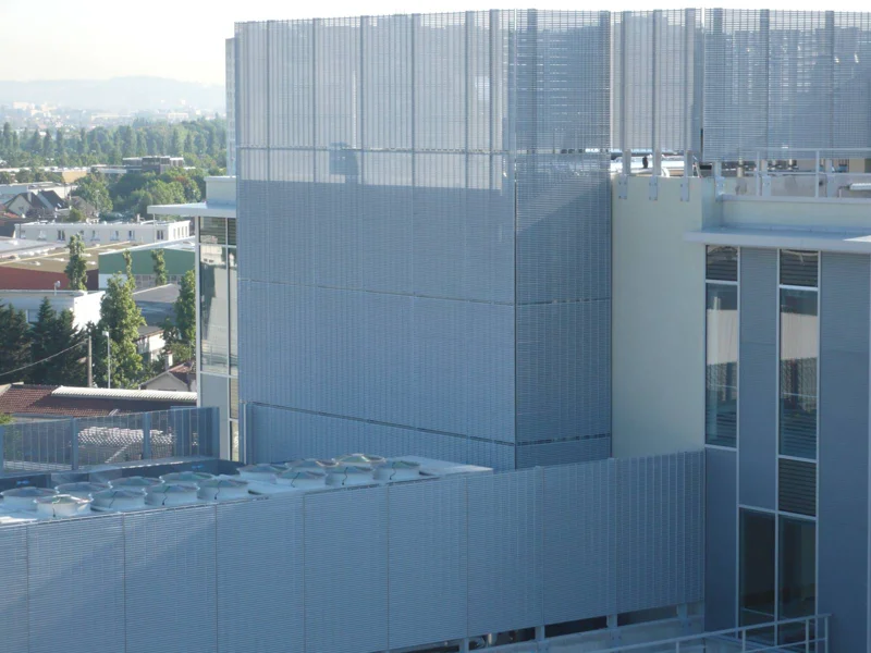 Habillage de façade d’un complexe industriel réalisé en caillebotis à lames inclinées