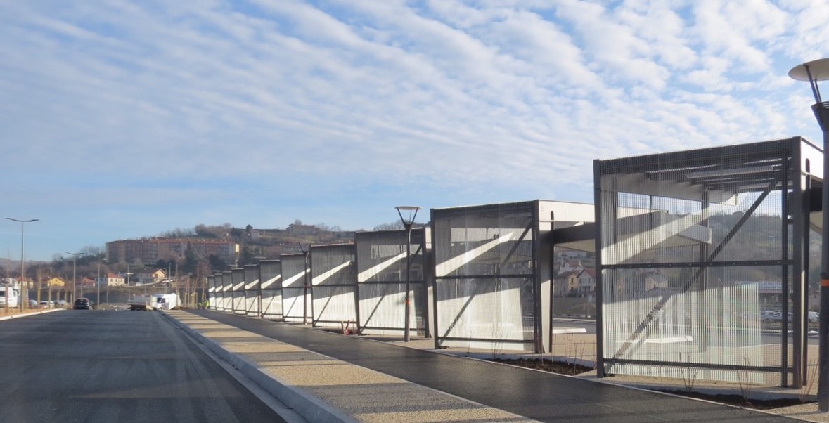 Abribus d’une gare interurbaine avec fond en caillebotis protégeant les voyageurs de la circulation automobile