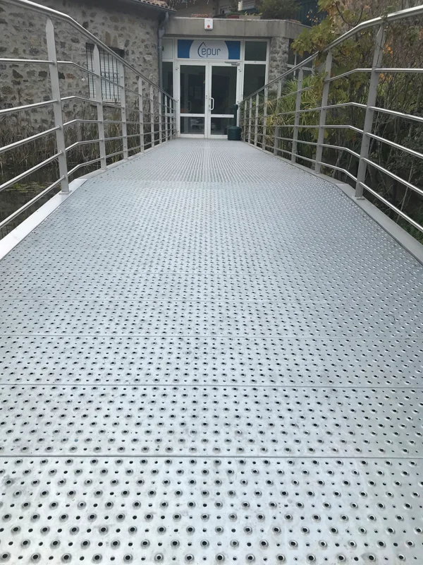 Passerelle piétonne réalisée en grilles de sécurité